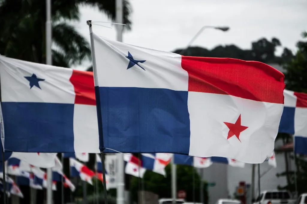 Panamanian flags flying in a row under an overcast sky, one flag sharp in the foreground