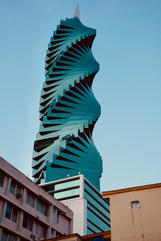 The F&F Tower in Panama City, a teal glass spiral skyscraper against a clear sky