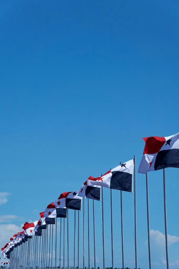 A receding row of Panamanian flags against a clear blue sky